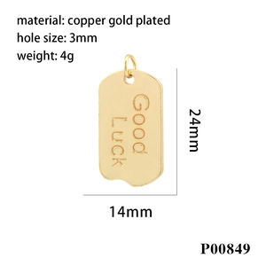 Macro detail of a 24x14mm gold-plated copper pendant engraved with Good Luck text