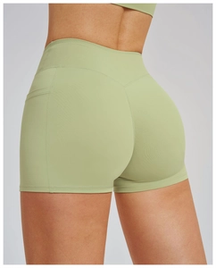 Close-up of high-waisted yoga shorts in light green with functional side pockets