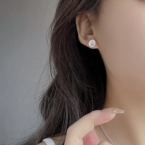 Detail of S925 silver tulip stud earring with pink glaze on an Asian model's ear