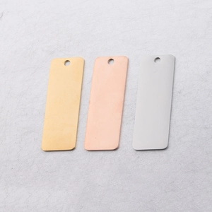 Detailed view of rectangular mirror-polished stainless steel charms in gold, rose gold and silver