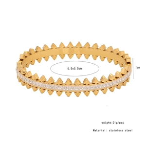 Detail view of gold stainless steel bangle with full crystal pavé and rivet design metrics