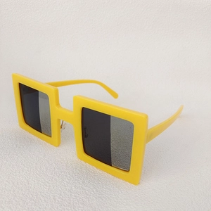 Detail view of yellow square frame sunglasses with gradient grey lenses from a side angle