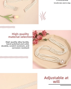 Detail of multi-layer pearl waist chain with elegant floral crystal buckle on pink background