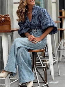 Elegante camicetta a fiori con maniche a lanterna e jeans blu a gamba larga a vita alta