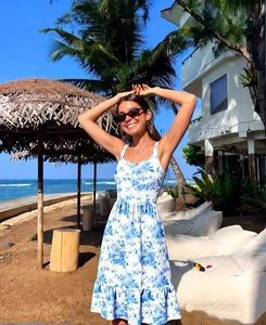 Detail of white and blue floral summer dress with tie straps at a sunny beach resort