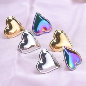 Polished stainless steel heart earrings in gold, silver, and rainbow on satin fabric