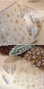 Macro detail of 3D relief Christmas nail stickers with gold foil snowflakes and trees