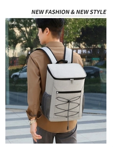 Detail of grey insulated backpack with reflective strip and front bungee cord storage