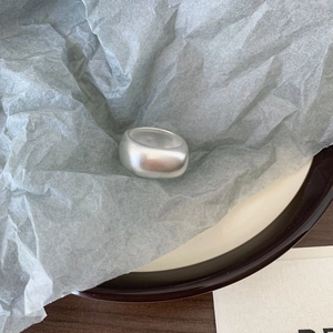 Detail view of a matte 925 sterling silver minimalist ring on grey textured paper