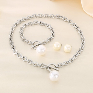 Detail of silver chain jewelry set with white pearls and OT buckle on silk fabric