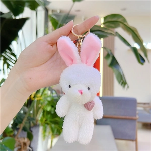 Gros plan d'un porte-clés lapin en peluche blanc avec cœur rose et crochet en métal doré