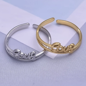 Detailed close-up of gold and silver Love script rings in high-quality 304 stainless steel