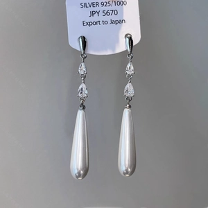 Gros plan des boucles d'oreilles en argent S925 avec perles d'eau et zircons brillants