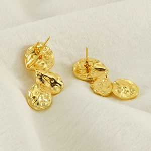 French vintage gold tiered lava earrings with irregular hammered petal texture on linen