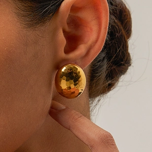 Detail of 18k gold plated stainless steel earrings with textured hammered finish on model