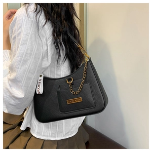 Detail of black textured underarm bag with gold chain and Parchita logo plate