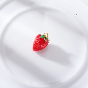 Detail of a 3D red strawberry charm with green leaves and a gold ring for DIY jewelry