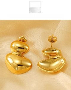 Detailed view of irregular gold double-layered pebble stud earrings on silk