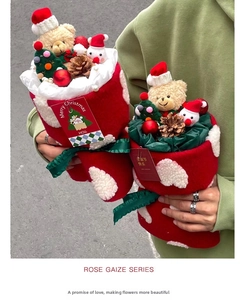 Detail of Christmas plush stocking bouquet with small bear, snowman and festive pine cones