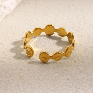 Gros plan d'une bague plaquée or 18 carats avec disques texturés et anneau réglable ouvert