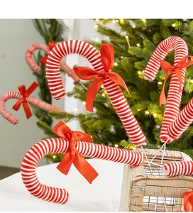 Close-up of red and white striped Christmas candy cane stake with a silk bow decoration