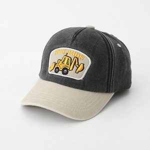 Detail of children's baseball cap featuring a yellow excavator embroidery and breathable holes