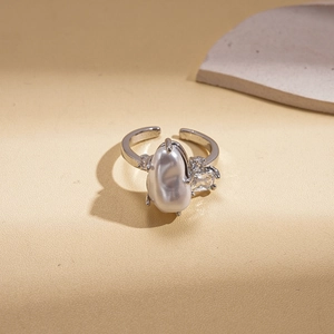 Macro detail of irregular baroque pearl and cubic zirconia on silver double-layer ring