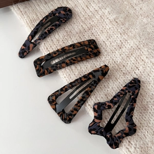 Detailed close-up of leopard print fabric BB hair clips in various geometric shapes