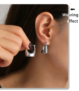 Close-up of elegant silver geometric hoop earrings worn by a model for a stylish look
