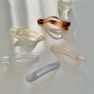 Set of five matte shark hair clips in amber, pink, and pastel shades on white background