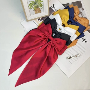 Close-up of assorted satin bow hair clips in vibrant colors with metal spring clips