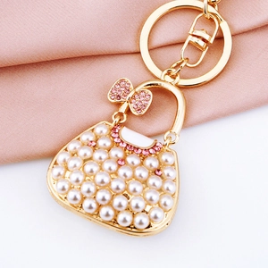 Close-up of pearl handbag keychain with pink rhinestones and gold-tone metal ring