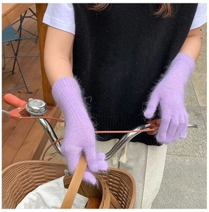 Close-up of purple knit plush gloves being worn while holding bicycle handlebars
