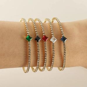 Close-up of five thin 18K gold-plated bracelets featuring colorful square zircon stones