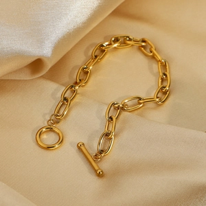 Classic gold paperclip link bracelet with OT toggle clasp on champagne silk fabric