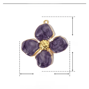 Macro view of purple enamel flower pendant with gold dotted edges and stainless steel core
