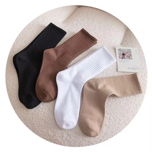 Close-up of four ribbed cotton crew socks in black, brown, white and khaki colors