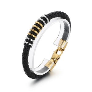 Black braided leather bracelet for men with gold and silver steel rings on clear stand