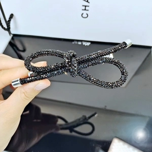 Dettaglio dell'elegante molletta a fiocco con strass neri e punte in argento