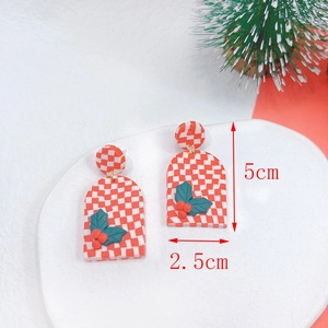 Detail view of handmade Christmas earrings with red checkered pattern and holiday motifs