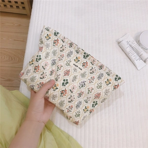 Detailed shot of floral canvas makeup bag with Simple Wish label and quilted background