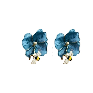Vintage style blue enamel flower earrings with yellow bee charms on a white background