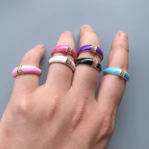 Close-up of colorful enamel gold plated rings with zircon inlay worn inside a vehicle