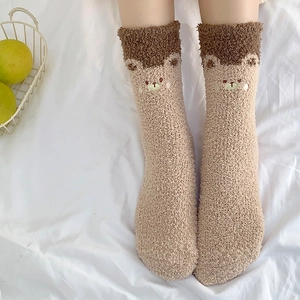 Close-up of cute bear embroidery on warm beige and brown coral fleece socks