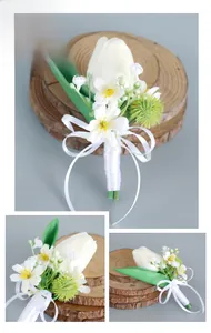 Detailed view of a white PU tulip boutonniere with baby's breath and ribbon bow