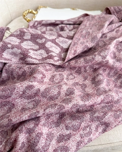 Close-up of the soft leopard jacquard texture on pink and beige cashmere-feel scarf