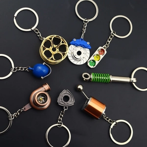 Car tuning parts keychain set including turbo, wheel rim, and helmet in metal finish