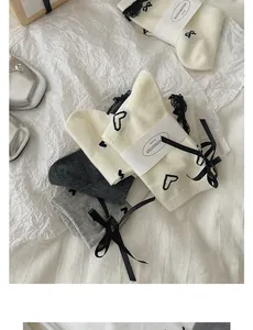 Detail of sweet cotton socks with heart patterns, lace trim and delicate bows