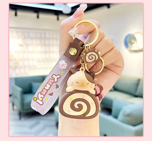Detail of cute cat on Swiss roll plush keychain with YUMMY silicone purple strap
