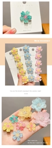 Close-up of pastel cherry blossom hair clips in mint green, yellow, pink and light blue
